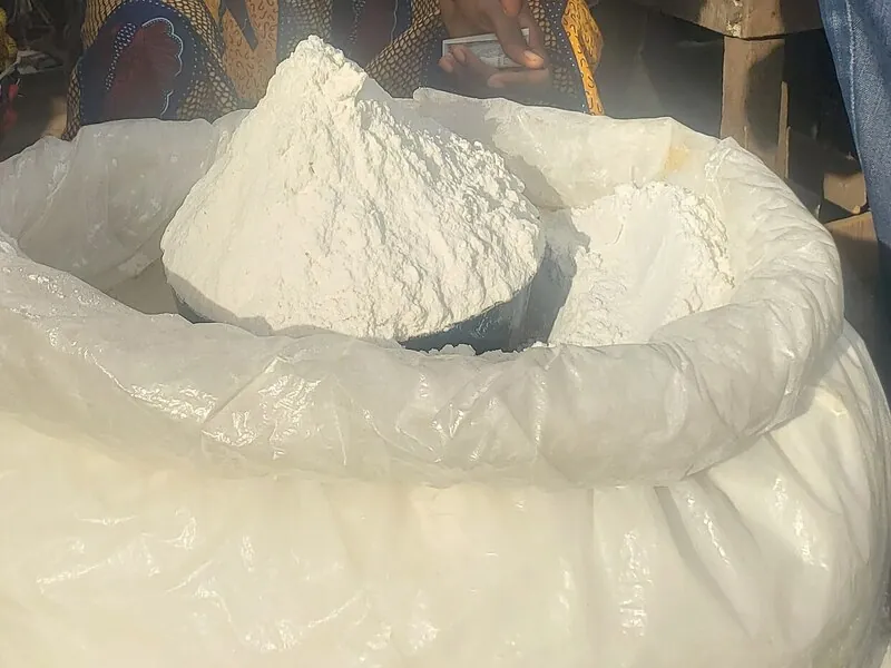 An open sack of fine white yam flour at a market stall